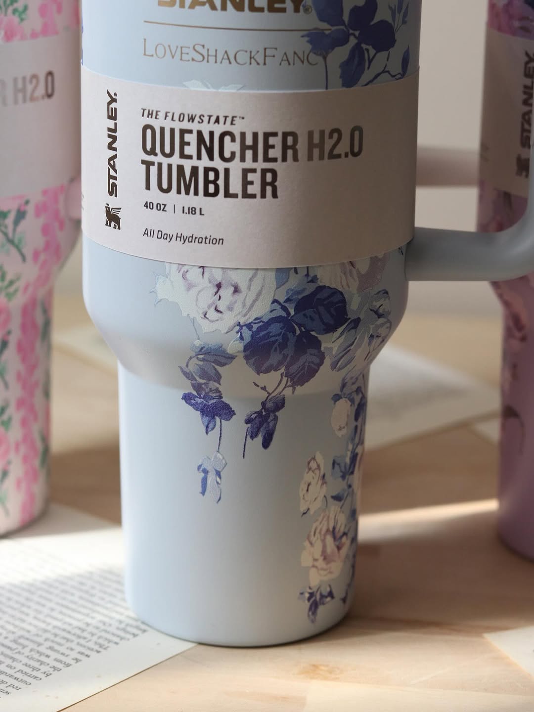 Floral-patterned tumbler with 'Stanley' branding on a wooden surface