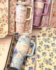Floral-patterned tumblers with handles on a floral background