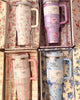 Set of floral-patterned mugs in gift boxes on a floral background