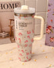 Lifestyle shot of Stanley LoveShackFancy floral tumbler held in hand with soft pink background