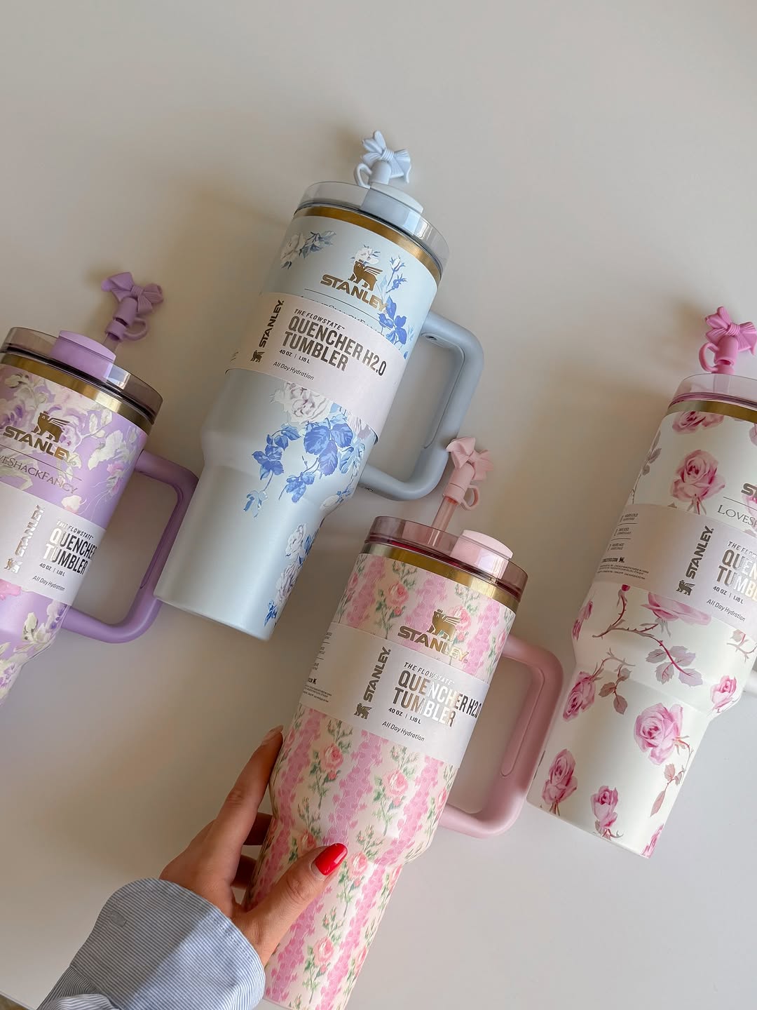 Set of floral-patterned tumblers with handles on a light background