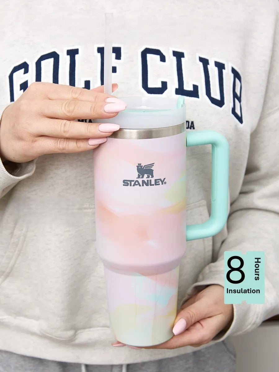 Person holding a colorful Stanley tumbler with a pastel gradient design.