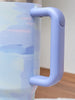 Close-up of a purple handle on a glass container with a blurred background