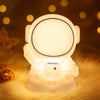Astronaut Night Lamp on a nightstand illuminating a cozy bedroom with soft, adjustable LED light